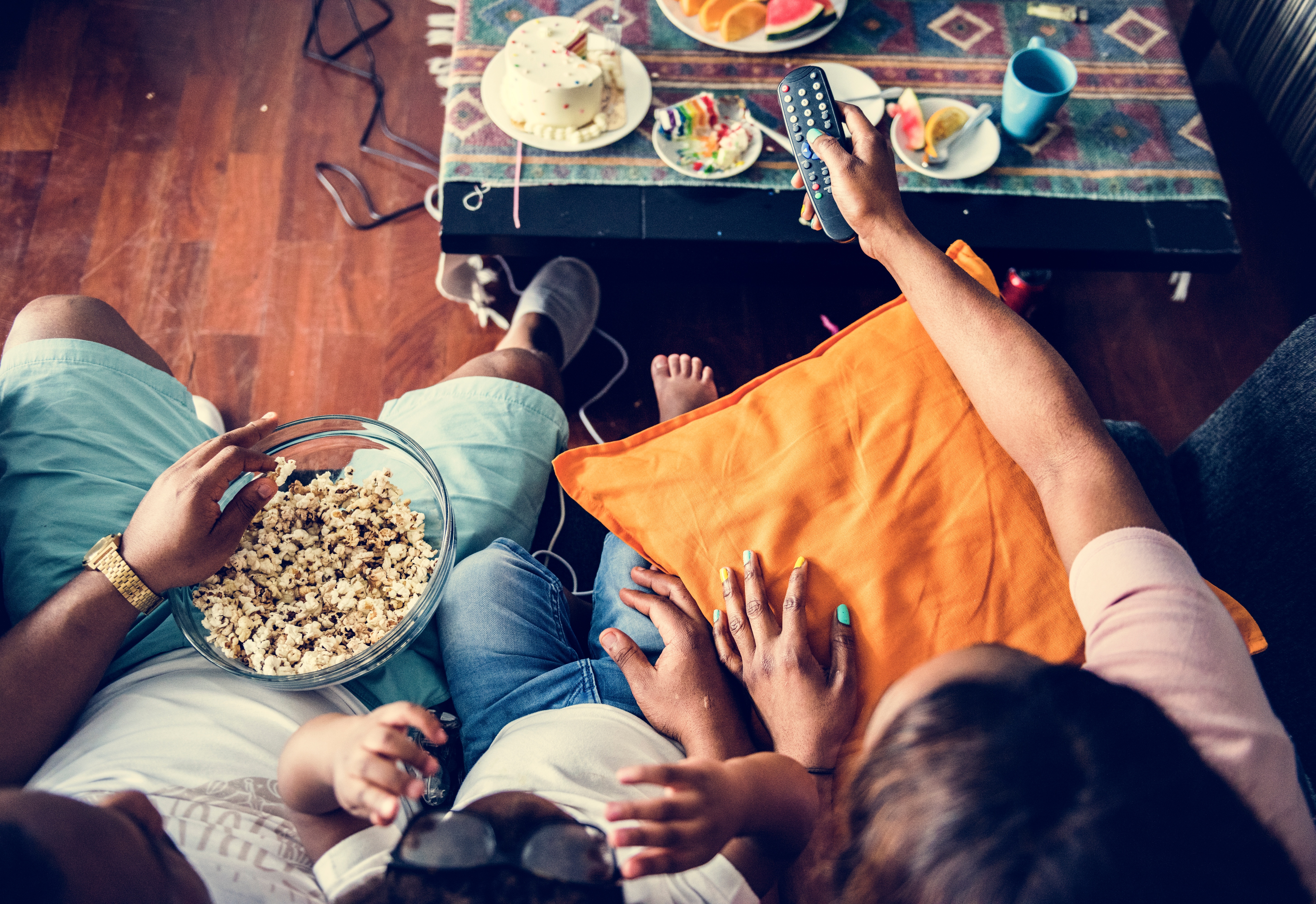 Family watching tv and eating snacks